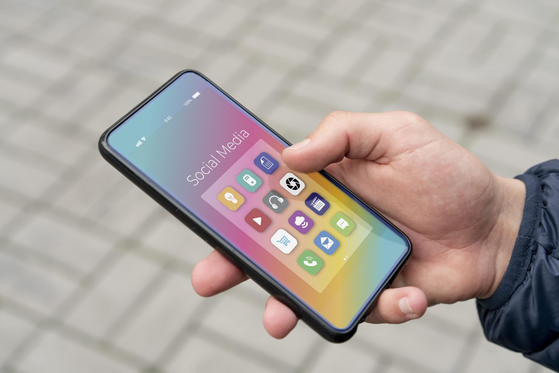 person's hand holding a phone showing apps